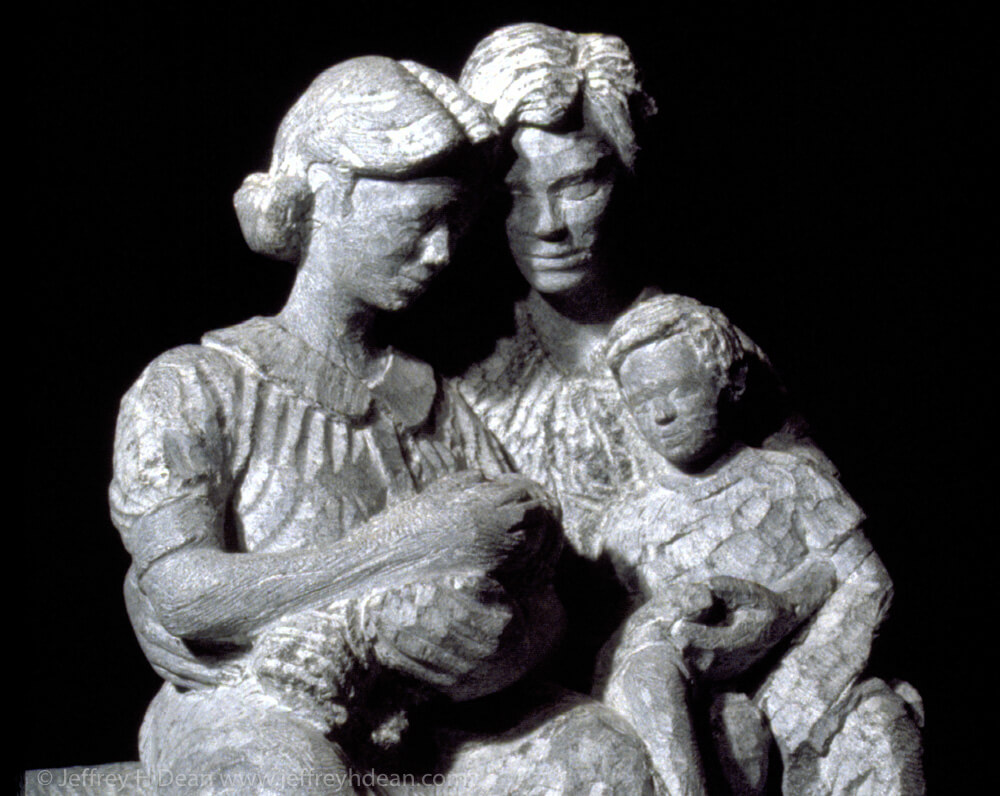 Stone carving of family with newborn child