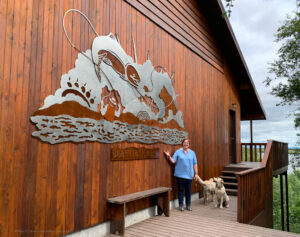Stainless steel and Corten layered exterior metal wall sculpture at Bear Trail Lodge in King Salmon, Alaska. An example of large metal wall art for outdoors.