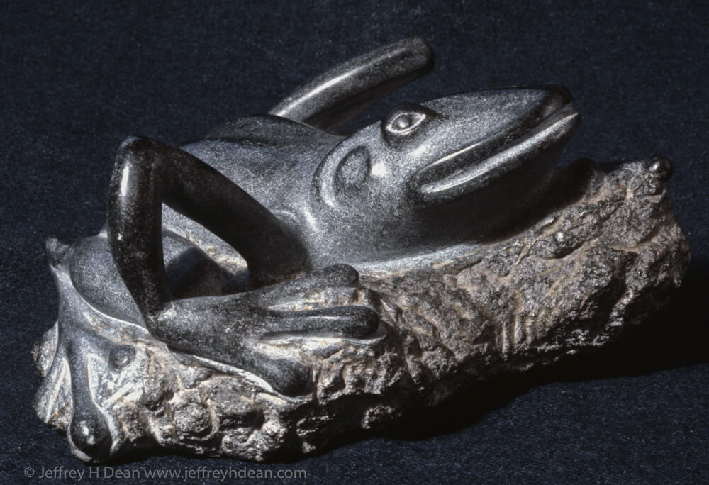 Stone carving of a large, rather indulgent, sunbathing tree frog.