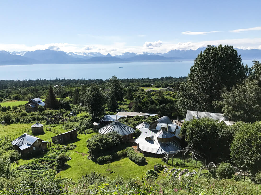 A Dean Homestead and Art Studios tour may be one of the highlights of the things you do while visiting Homer, Alaska. View of the Dean farm from the hill behind Dean Family Farm and Art Studios overlooking Kachemak Bay and the Kenai Mountains.