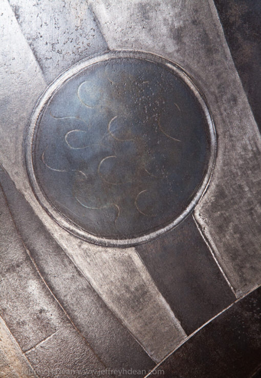 Earth, air, fire and water; the resources of the smith. Engraved steel sawblade of blacksmith in the forge.