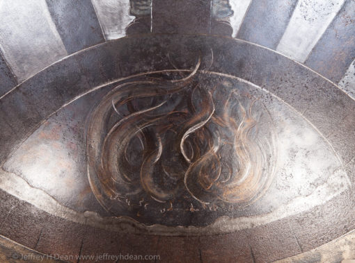 Earth, air, fire and water; the resources of the smith. Engraved steel sawblade of blacksmith in the forge.
