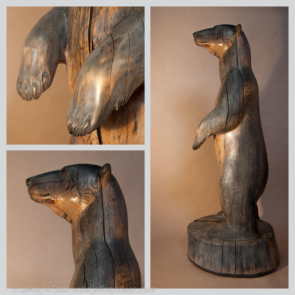 6.5' tall white spruce carving of polar bear in the rays of the first arctic sun.