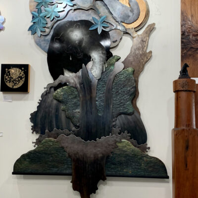 layered large metal wall art of a fishing bear and raven.