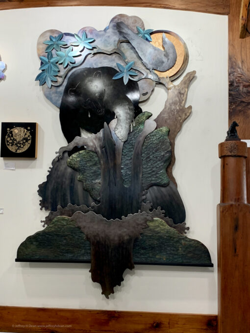 layered large metal wall art of a fishing bear and raven.
