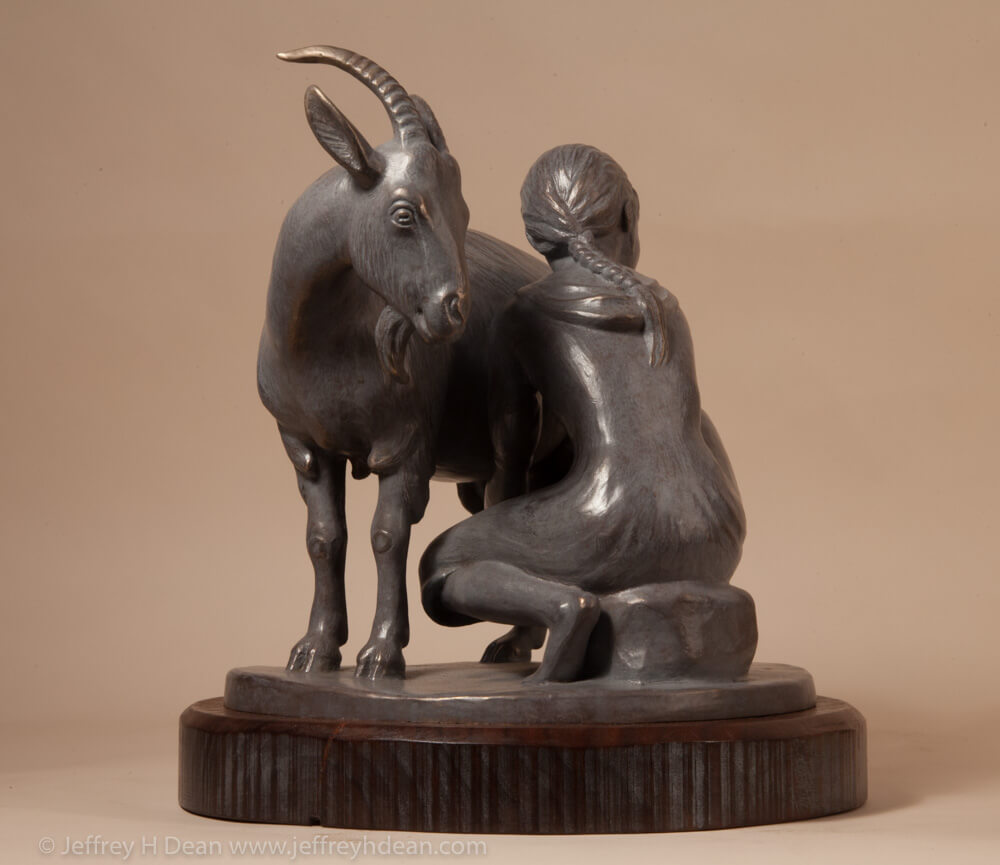 Bronze sculpture of girl milking goat.