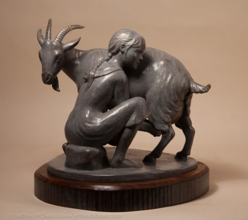 Bronze sculpture of girl milking goat.