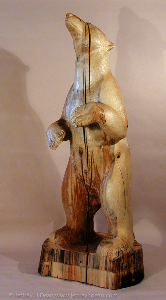 White spruce carving of polar bear sniffing at the wind.