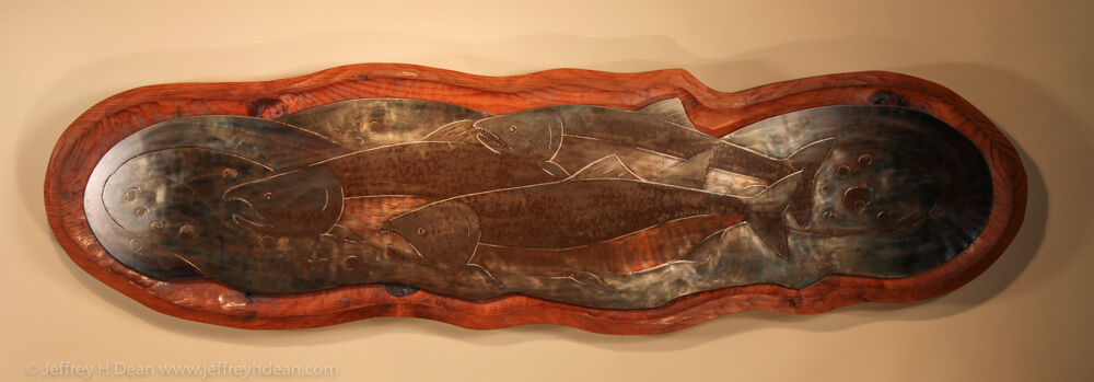 Three salmon rest in the shallow headwaters of a northern stream bed. Engraved steel metal wall art