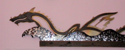 Wall relief of sea dragon frolicking in the waves. Weathered fir, stainless steel and brass wood and metal wall art