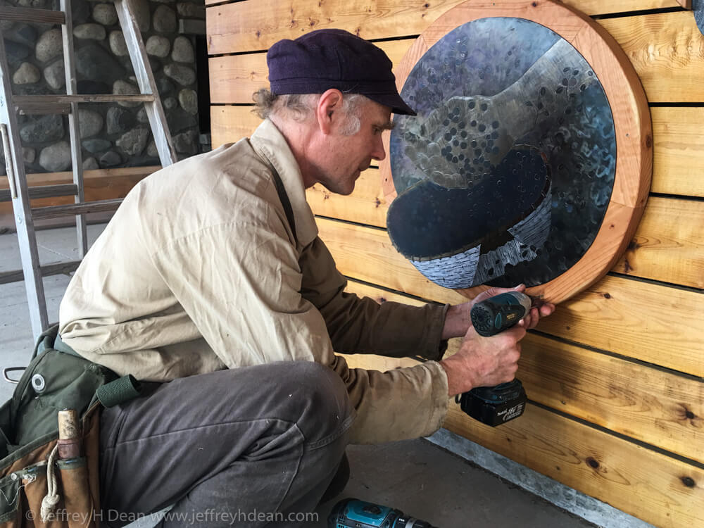Jeffrey H. Dean installing bearing picking picture as part of Through Your Spotting Scope percent for art commission at Denali State Park.