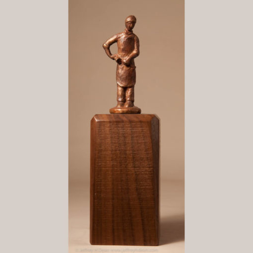 Bronze miniature sculpture of a woodcarver holdiing his mallet and chisel.