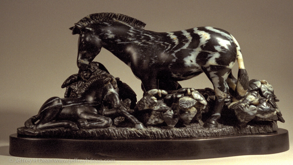 Striped soapstone carving of mother and baby zebras.